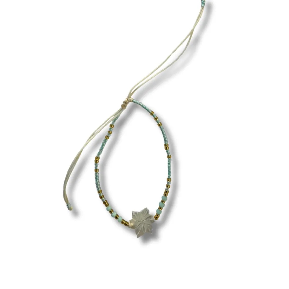 bracciale_regolabile_con__1.webp Bracciale regolabile con fiore di madreperla e perline di vetro